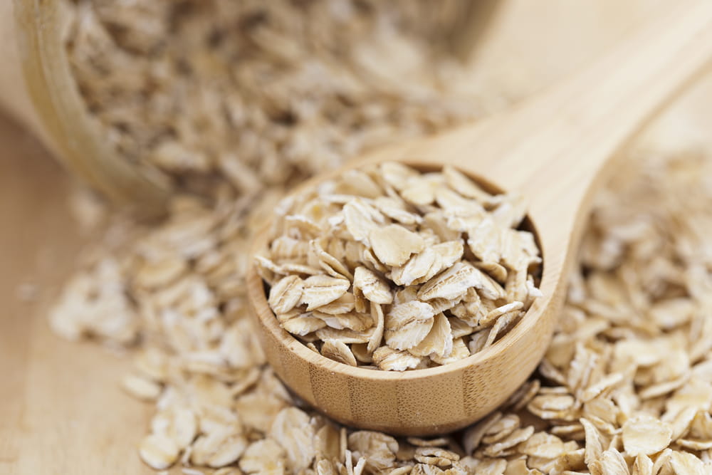 Healthy dry oat meal in wooden spoon