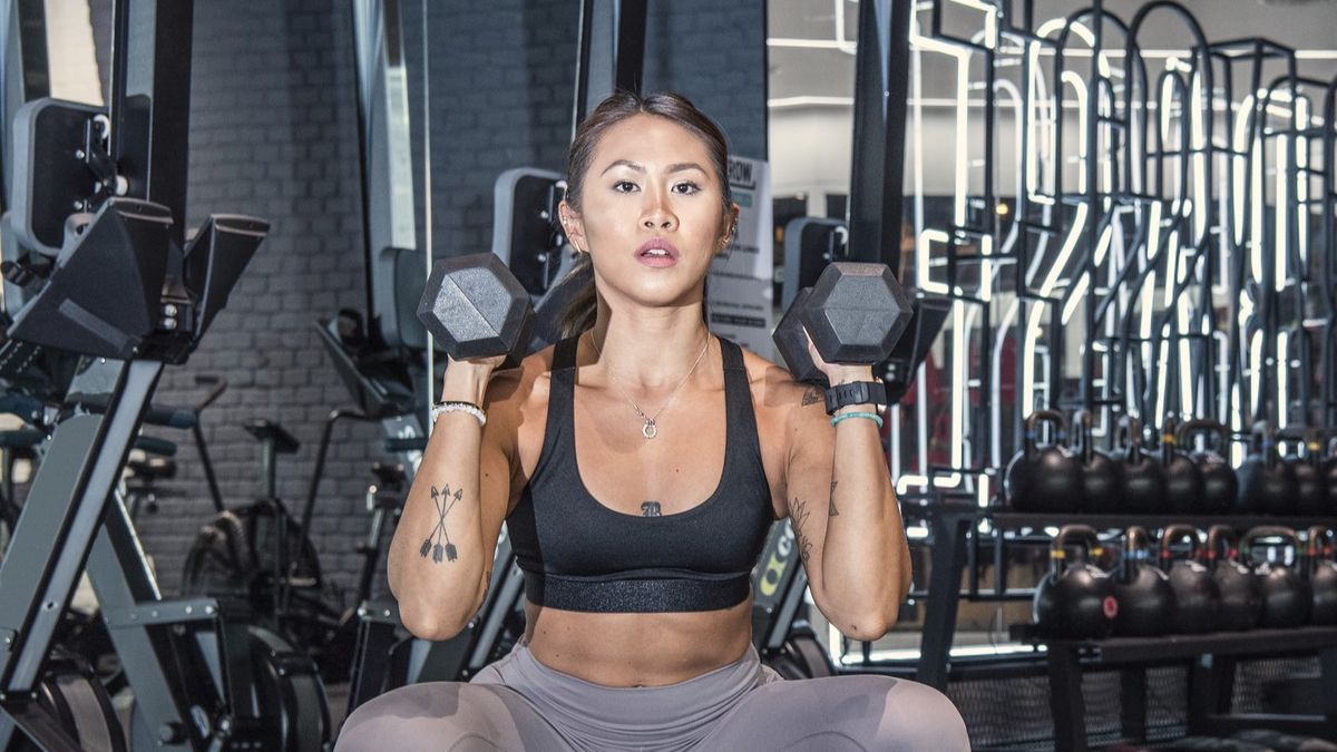 a photo of a woman holding two dumbbells doing a squat